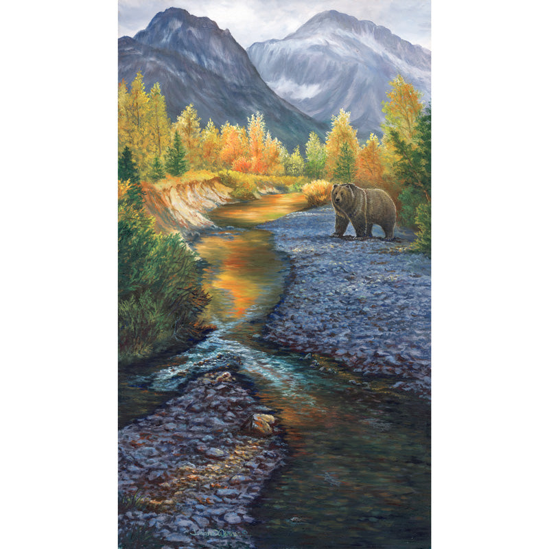 A Grizzly bear alongside McDonald Creek in Glacier National Park, with colorful autumn trees and mountains in the background. By Artist Jeanne Warren