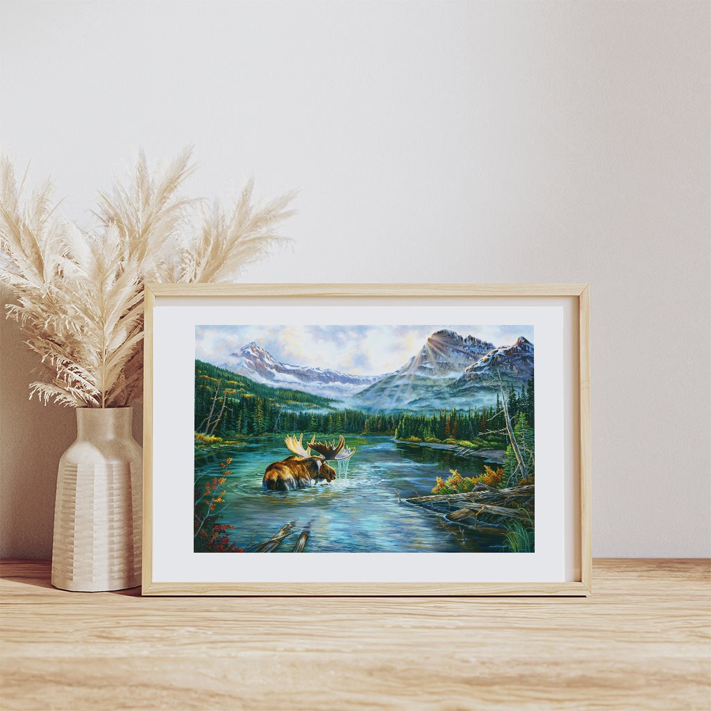 Heavy Shield Warrior Moose painting giclée paper print in natural wood frame, resting on wooden table. By artist Jeanne Warren