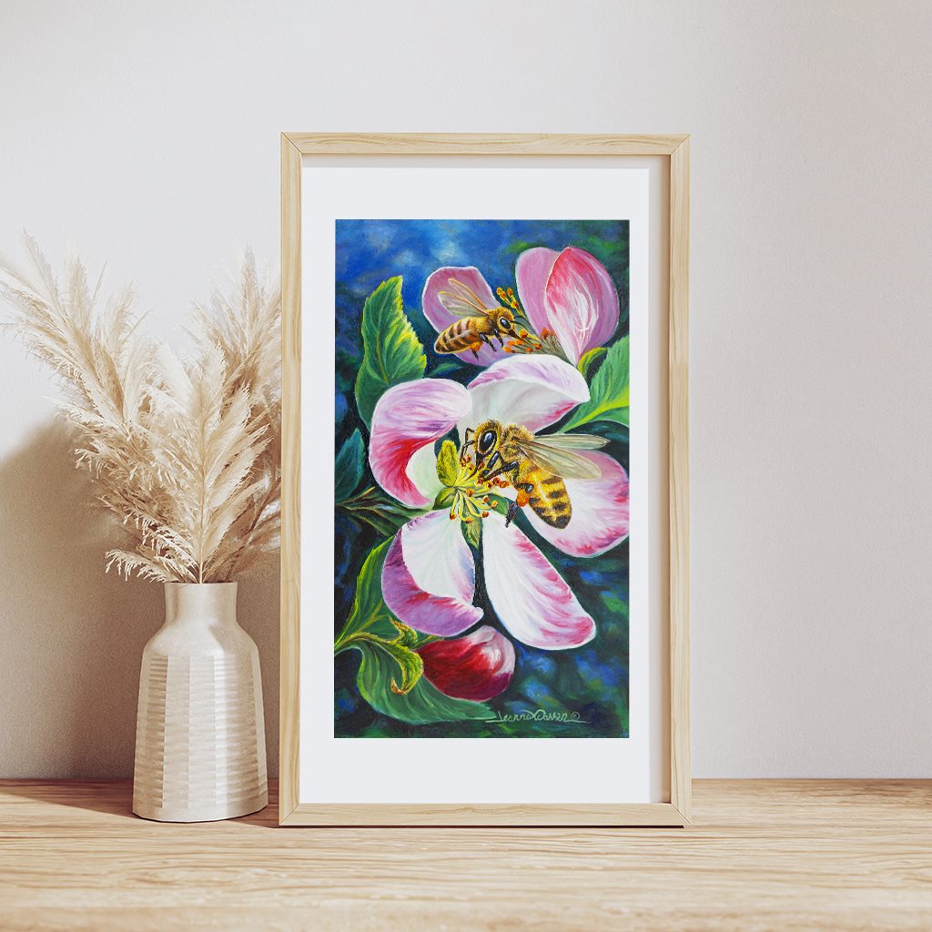 Honey Bee Blossoms giclée paper art print in natural wood frame, resting on wooden table, by artist Jeanne Warren