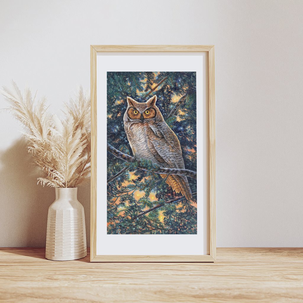 Great Horned Owl Bird of Prey Wildlife Art Print showing a majestic owl perched on a blue spruce branch, surrounded by glowing orange and yellow lights filtering through evergreen branches. The owl's striking golden eyes and detailed feathers are captured in rich, natural colors.